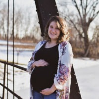 surrogate holding belly in surrogacy photo shoot