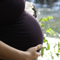 Minnesota surrogate mother holding surrogacy pregnancy bump