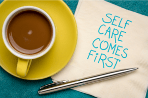 coffee mug next to napkin that says "self care comes first"